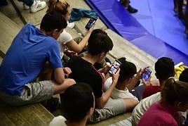 Imagen de archivo de un grupo de jóvenes con sus teléfonos móviles.