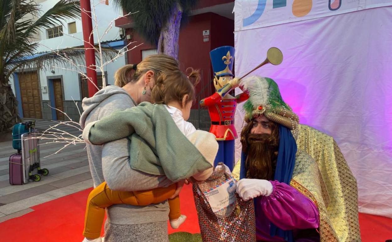 El paje real atiende a una niña en una de sus visitas a los barrios. 