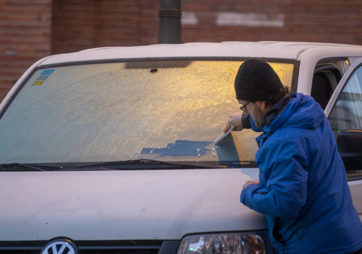 Un hombre rasca el hielo del parabrisas de su vehículo en la madrugada de este miércoles en Vitoria