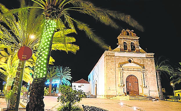 Imagen principal - Arriba, la ermita de la patrona insular en Vega de Río Palmas. Abajo, luces a la entrada del Valle de Santa Inés y velas en la iglesia de Betancuria. 