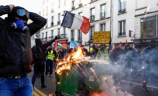 Contenedores de basura en llamas durante una protesta convocada este sábado por organizaciones juveniles en París. 
