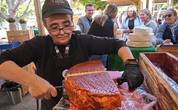 Ganadera parte un queso en la feria. 