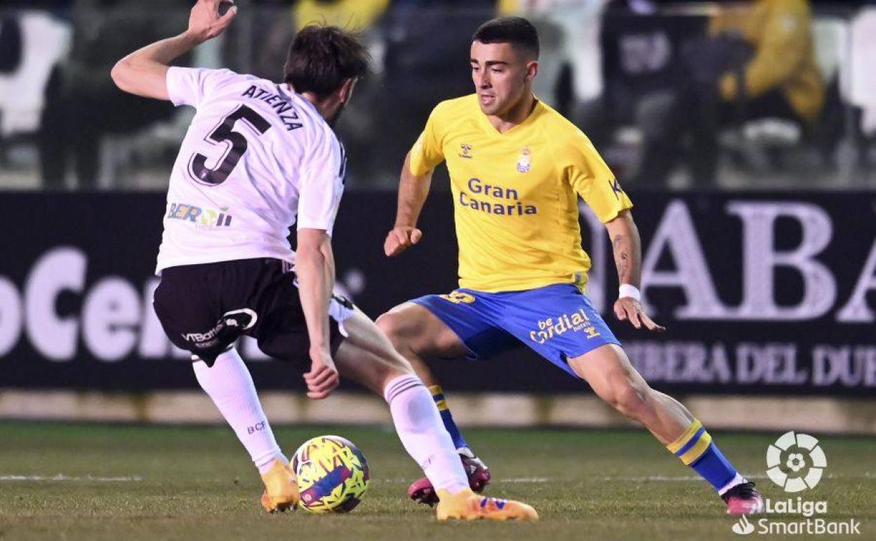 Moleiro controla el balón ante la atenta mirada de Atienza. 