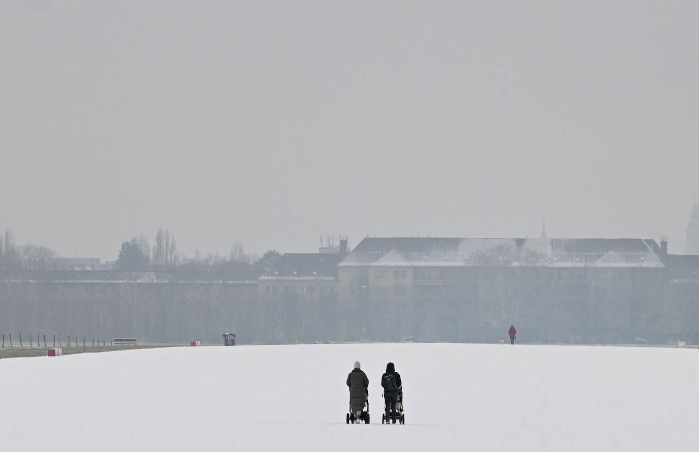- La gente camina sobre la antigua pista del aeropuerto cubierta de nieve en el campo Tempelhof durante un día frío en Berlín, Alemania, el 06 de febrero de 2023. El clima invernal con baja temperatura sigue prevaleciendo en Alemania. 