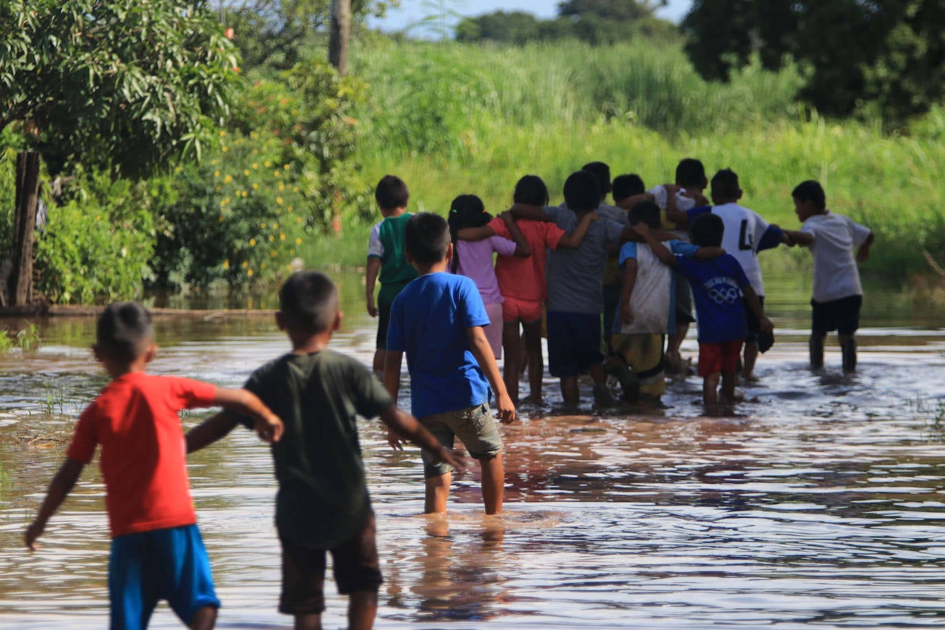 Unos niños caminan en medio de una inundación en la comunidad Rancho Chico perteneciente al municipio de Okinawa I, en Santa Cruz (Bolivia). Las lluvias e inundaciones registradas en Bolivia en los últimos días han dejado hasta el momento dos personas fallecidas y más de 5.000 familias afectadas. 