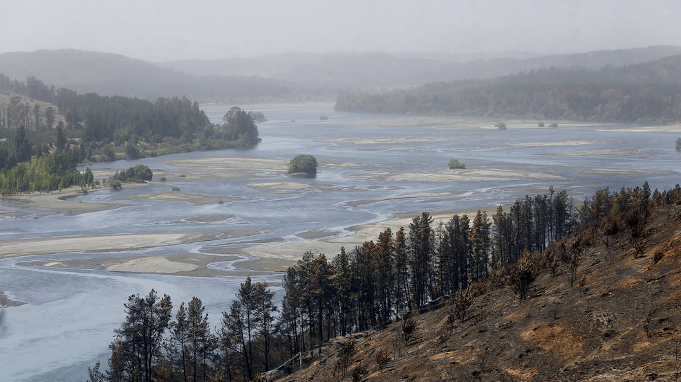 Fotografía de un terrenos consumidos por el fuego con el Río Bío Bío en el fondo, en la comuna de Santa Juana (Chile). Los incendios que son combatidos en Chile descienden a 53 y la emergencia se consolida en "fase de contención", aunque la alerta por climatología propicia para la generación de nuevos fuegos sigue activa en el centro-sur del país, en donde la tragedia deja ya más de 400.000 hectáreas calcinadas en las últimas dos semanas. 