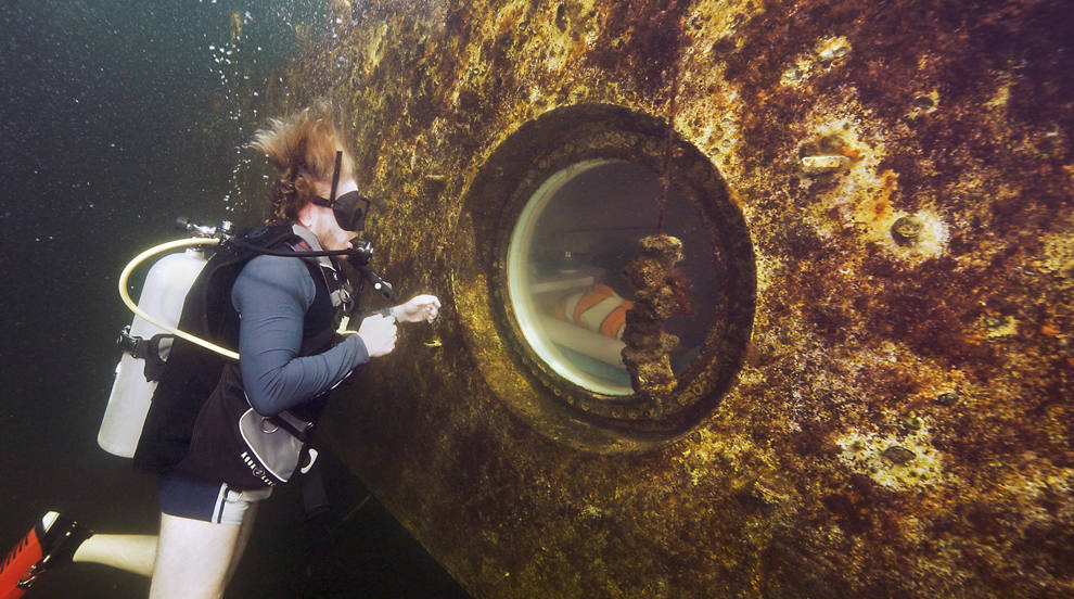 Fotografía donde aparece el investigador Joseph Dituri mientras observa el hábitat marino a través de un ojo de buey en el albergue submarino Jules Undersea Lodge en Key Largo, Florida (EEUU). El profesor asociado de la Universidad del Sur de Florida (USF) Joseph Dituri se propone vivir cien días sumergido en aguas de la Florida para realizar investigaciones médicas y de ciencias marinas y estudiar cómo responde el cuerpo humano a la exposición a largo plazo a la presión extrema. 