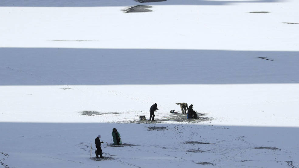 Pescadores de invierno faenan el hielo del río Dniéper en Kiev, Ucrania, en plena incursión rusa. Las tropas rusas entraron en territorio ucraniano el 24 de febrero de 2022, iniciando un conflicto que ha provocado destrucción y una crisis humanitaria. 