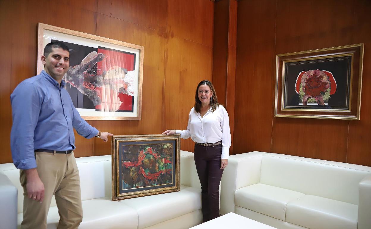 María Dolores Corujo y Benjamín Perdomo con las pinturas adquiridas por los Centros. 