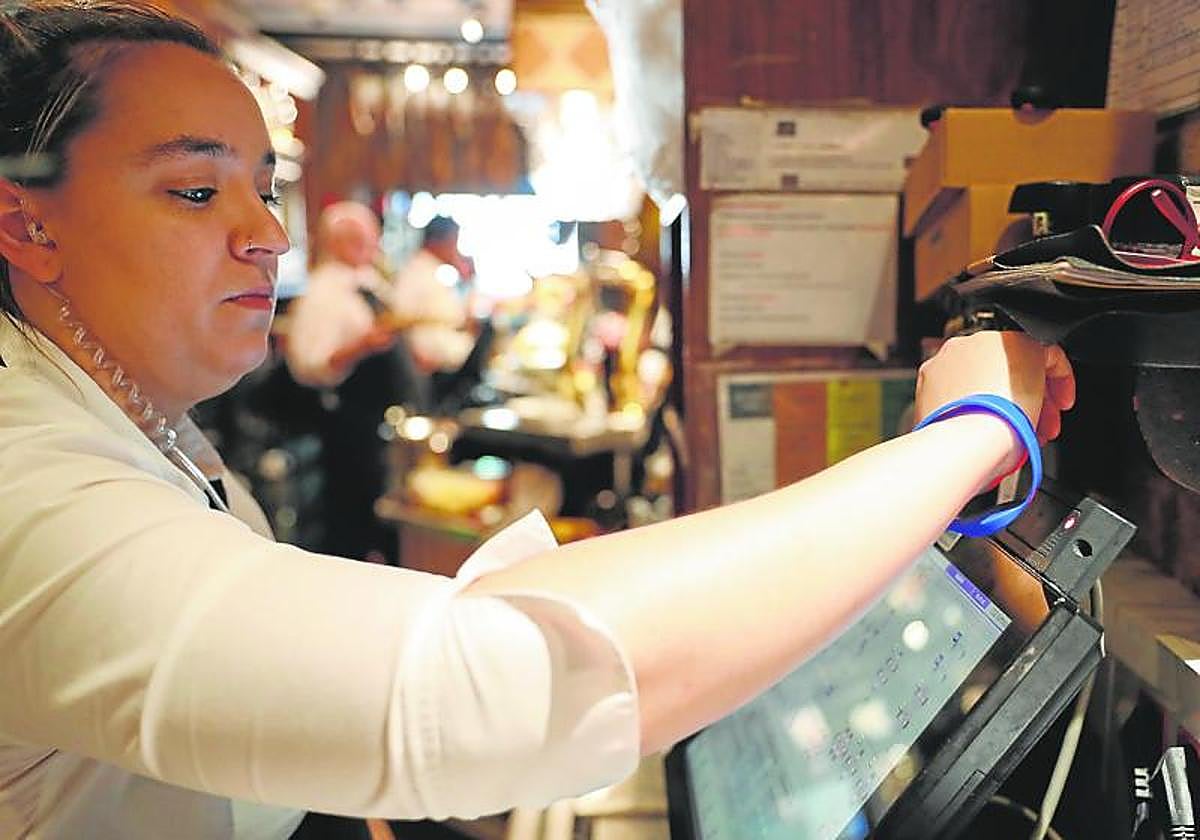 Una trabajadora ficha antes de comenzar su jornada laboral.