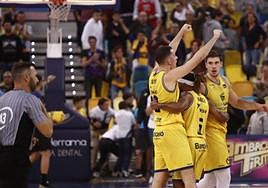 Salvó celebra una canasta abrazado por Albicy y con Happ de testigo cercano.