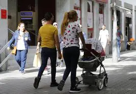 Una pareja paseando con su bebé en la calle Real de Arrecife.
