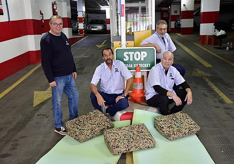 Imagen de algunos trabajadores con los colchones en la entrada del parquin.