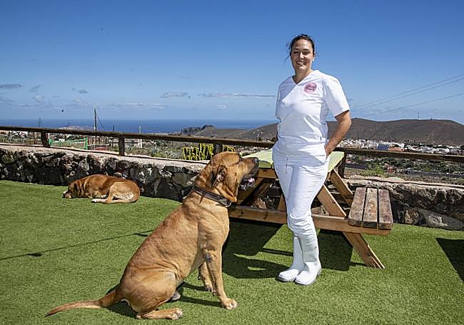 Anabel, posando con sus perros en la terraza de la granja.