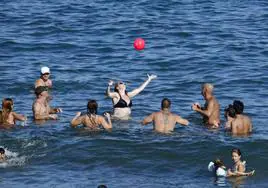 Imagen de archivo en el que un grupo de bañistas se refresca en Melenara.