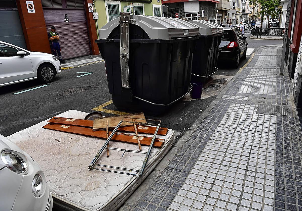 Imagen de un colchón tirado junto a los contenedores de basura.