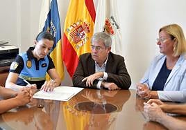 Guacimara Ojeda, en el momento de estampar su firma, en presencia del alcalde y de la edil de Recursos Humanos.