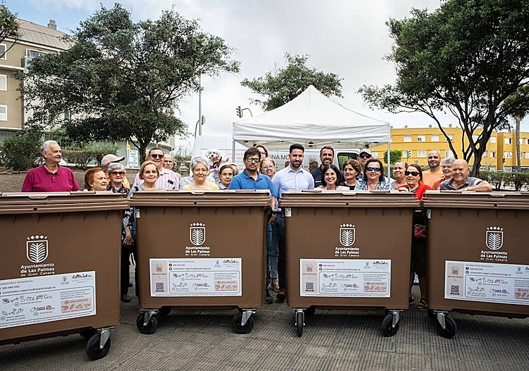 Los vecinos con la alcaldesa y el concejal junto a los contenedores que se instalarán en el barrio.