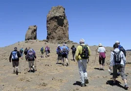 Turistas caminando por la explanada por la que se llega al Roque Nublo.