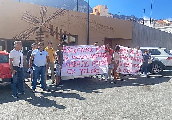 El empresario, con las gafas sujetas al cuello del polo, y una quincena de sus empleados, este viernes, durante la protesta ante el Ayuntamiento.