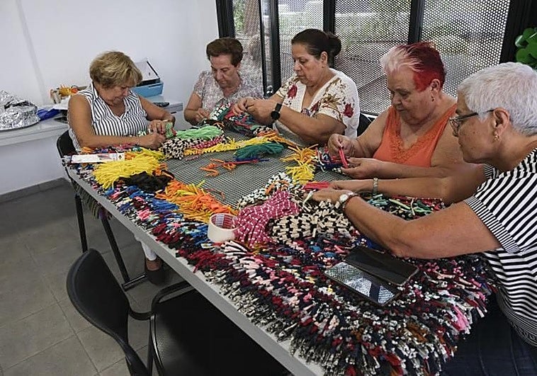 Vecinas liadas en la elaboración de una de las piezas decorativas.