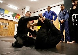 Fabricio Werdum observa a dos alumnos durante una de las clases prácticas.