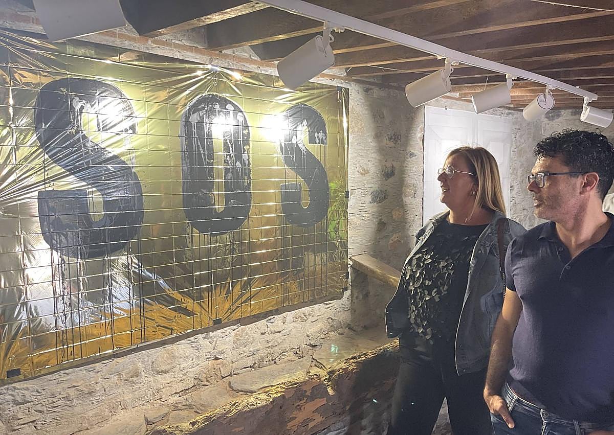 Imagen secundaria 1 - Víktor Arvín, tocando en la inauguración. Debajo, la concejal de Cultura, Elena Álamo, contemplando el xuadro de Mbaye junto al director del IES, Daniel Escobar. Mbaye hizo cinco de las cuadros de la muestra.