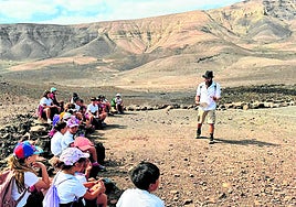 Derque Castellano, arqueólogo, explica el poblado de la Atalayita, en Pozo Negro, a los escolares.
