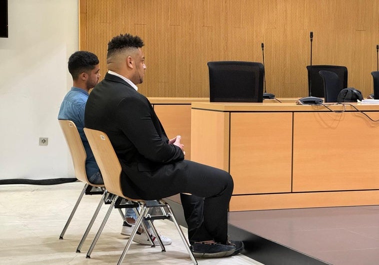 Los dos acusados, de espaldas, durante el juicio.