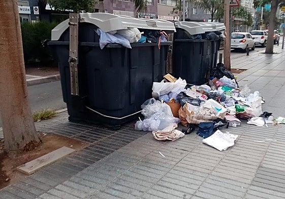 Los contenedores a rebosar en una calle en Triana.