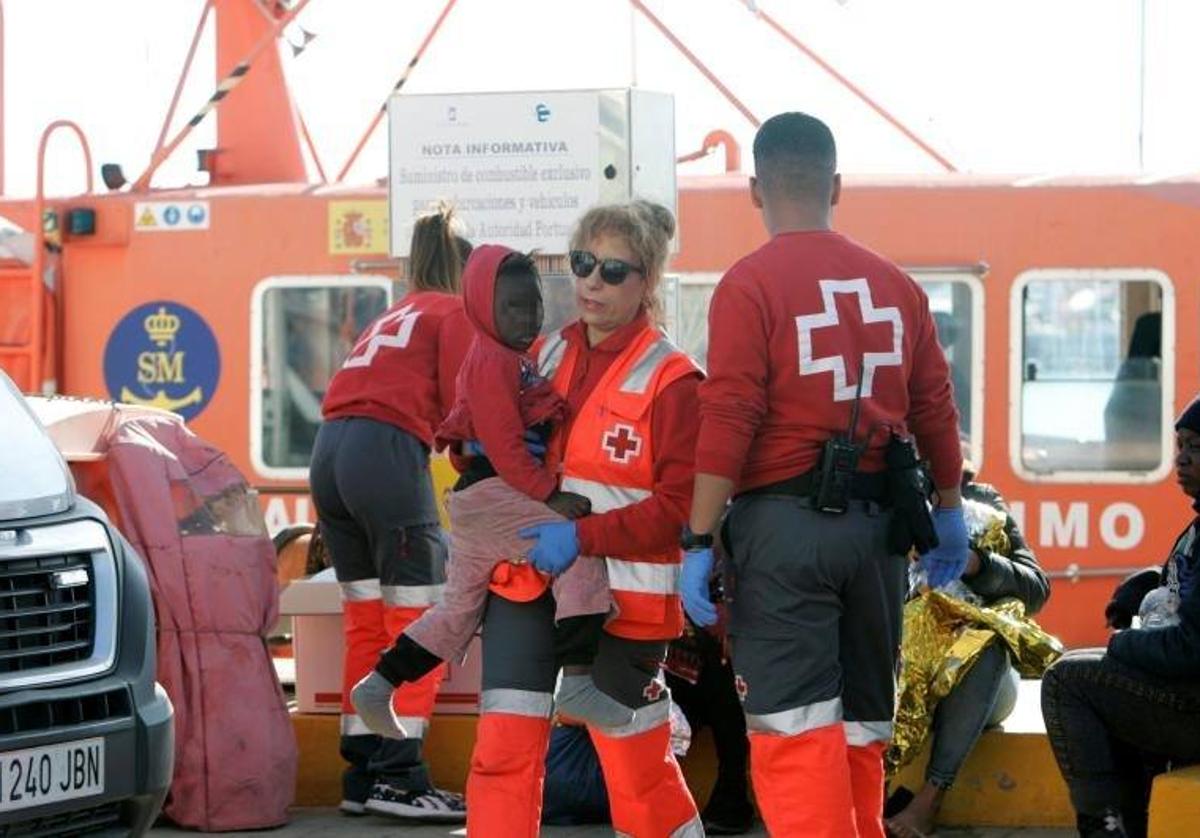 Personal de la Cruz Roja atiende a una niña llegada a las islas.