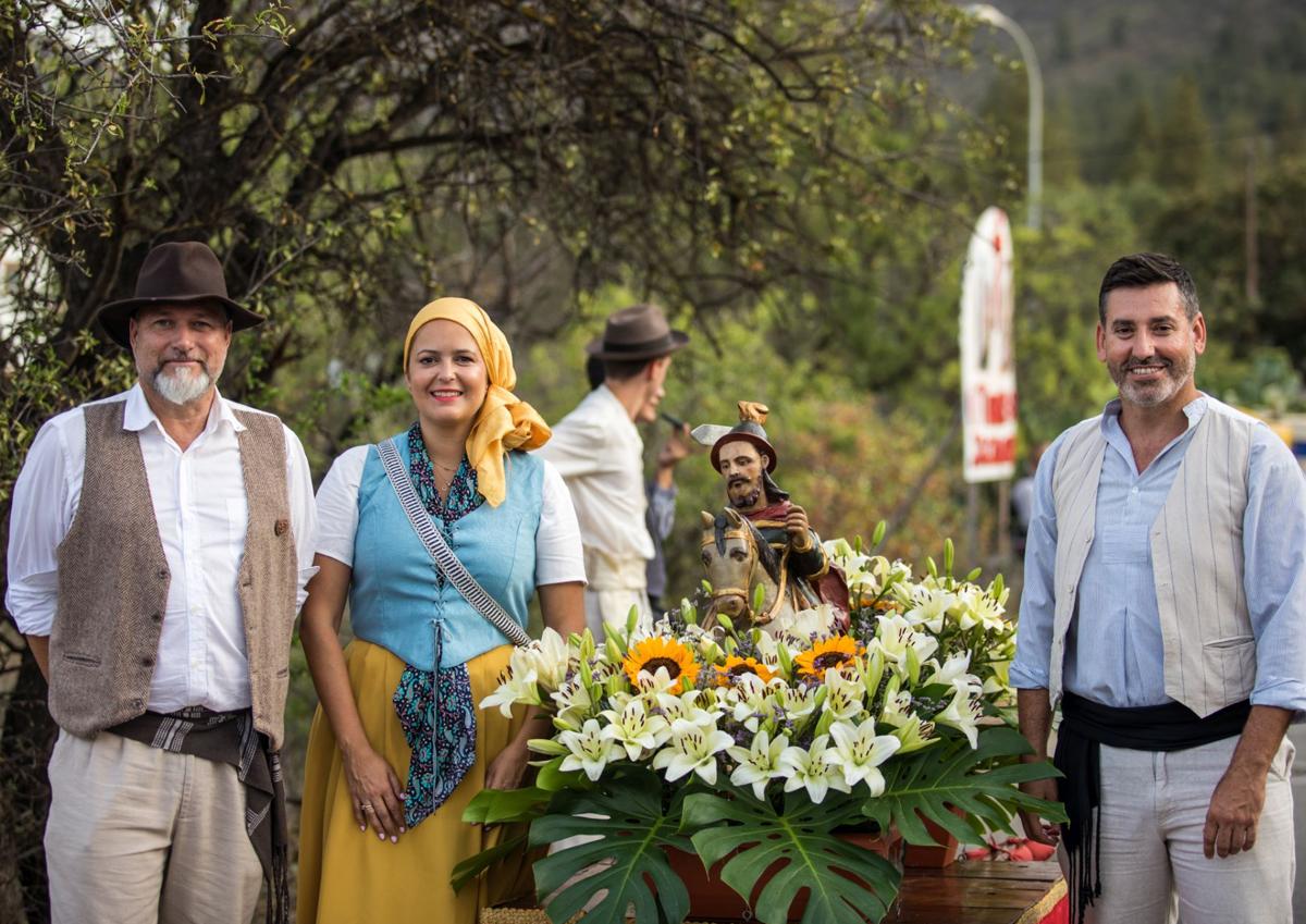 Imagen secundaria 1 - En la foto superior, bailarines llegados de El Hierro. Debajo, los ediles Dimas Sarmiento, Yilenia Vega y Alejandro Marichal posando junto a la talla de Santiago El Chico. Y al lado, un momento de la misa. 