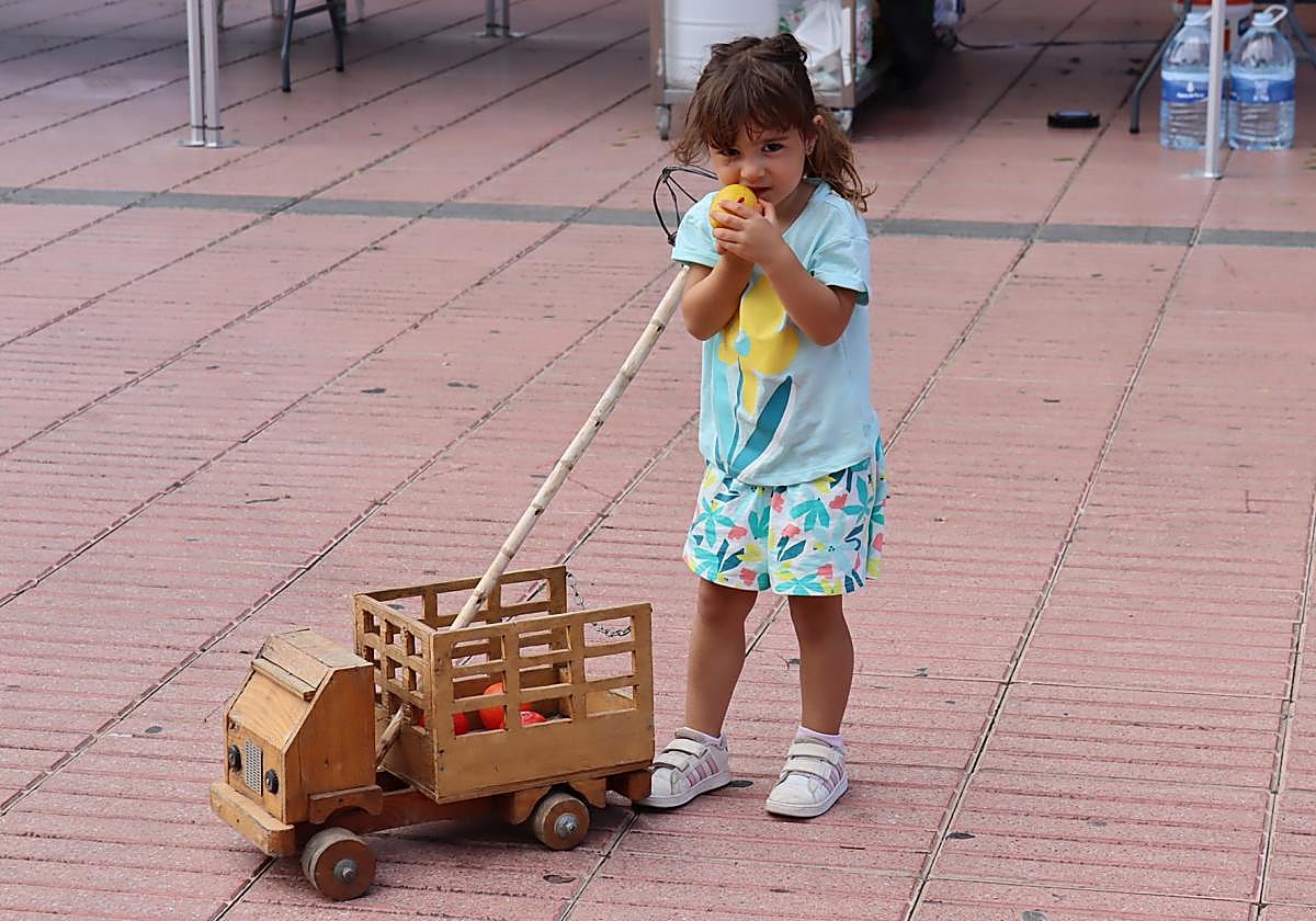 Una niña con un camión de madera en la plaza de La Candelaria de Ingenio.