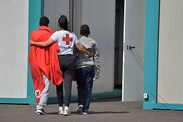 Dos menores migrantes junto a una trabajadora de Cruz Roja en su llegada a El Hierro la semana pasada.