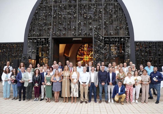 Foto de familia de cargos públicos y premiados frente a la fachada del Templo Ecuménico, en Playa del Inglés.