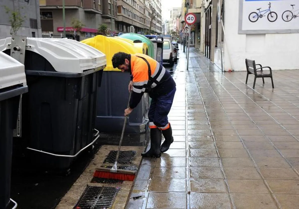 Un operario de Limpieza barre una de las calles de Triana.