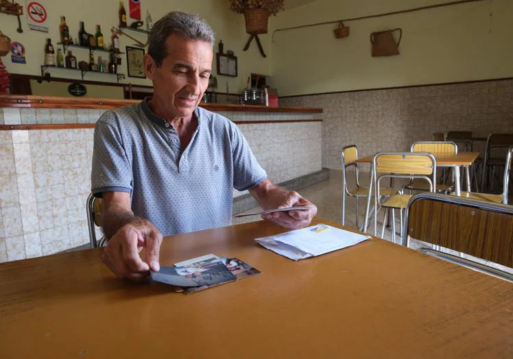 Sergio enseña las fotos antiguas de las parrandas de las fiestas de la Peña en su cantina.