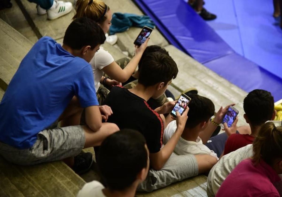 Jóvenes viendo su teléfono móvil.