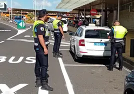 Tres agentes locales en la parada de taxis del aeropuerto en pleno control de tráfico y transportes.