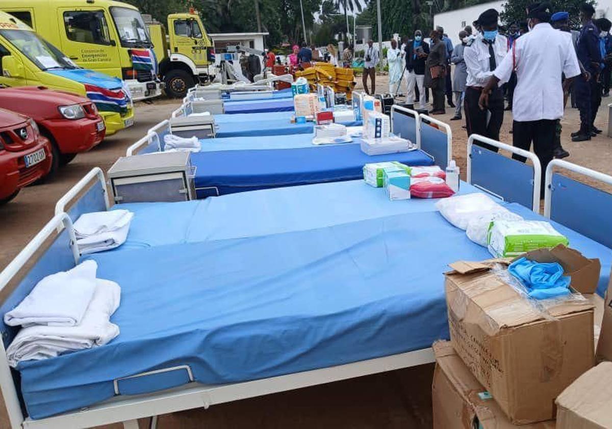 Imagen principal - La entrega de material sanitario y vehículos se llevó a cabo en el exterior de la residencia oficial del presidente del Gambia, Adama Barrow. 