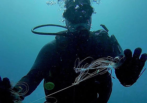 Un submarinista recoge nylon del fondo del mar en la primera inmersión de Fuertebuceo.