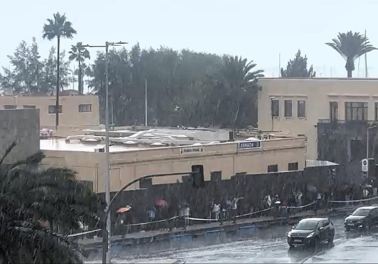 Imágenes de las colas sobre el Arsenal, em mitad de la lluvia.