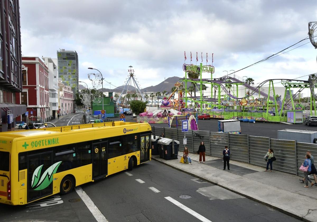 Una guagua entra en Eduardo Benot en la zona donde está la feria del carnaval de Las Palmas de Gran Canaria.