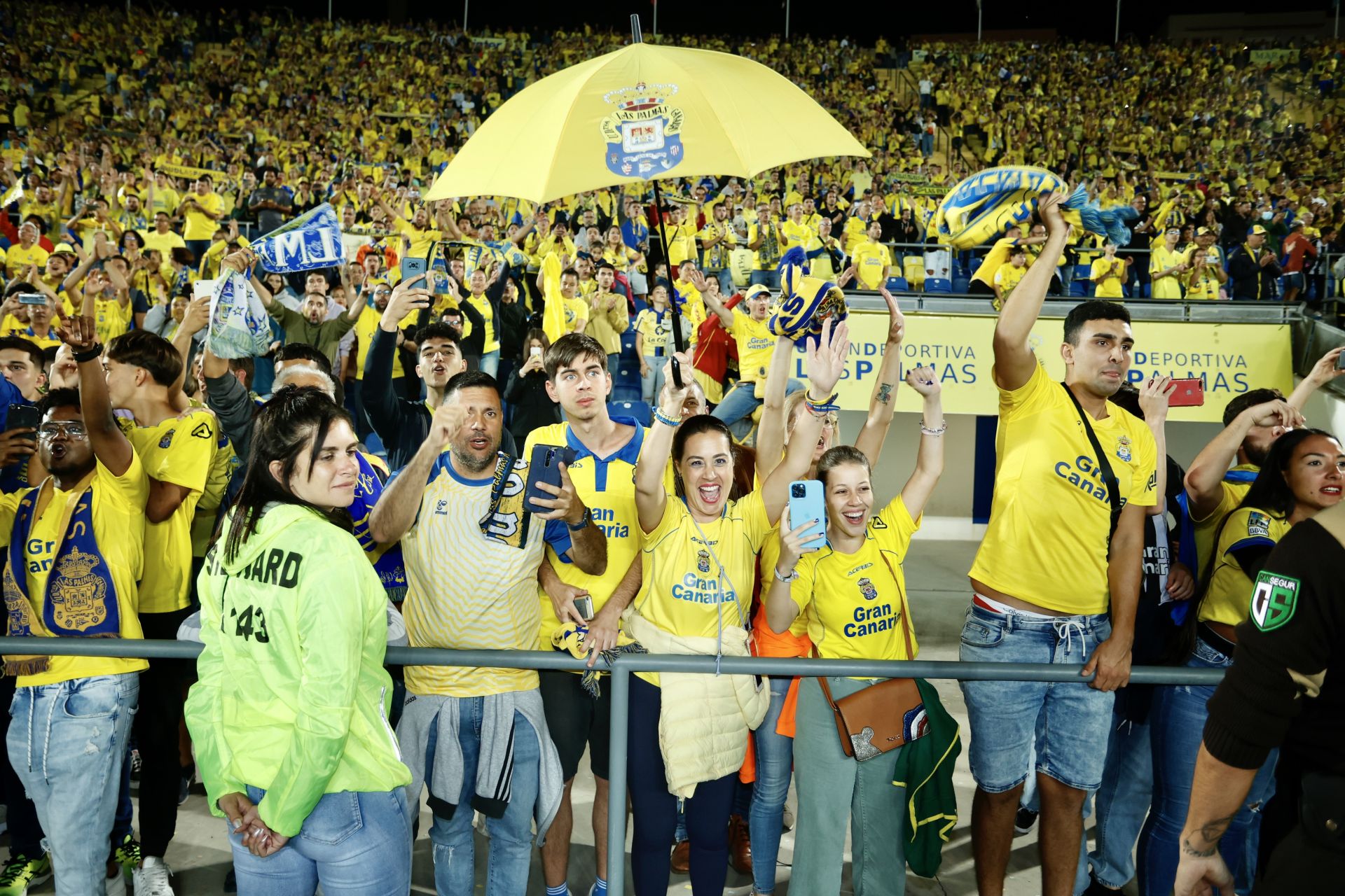 Aficionados amarillos alientan la noche del ascenso.