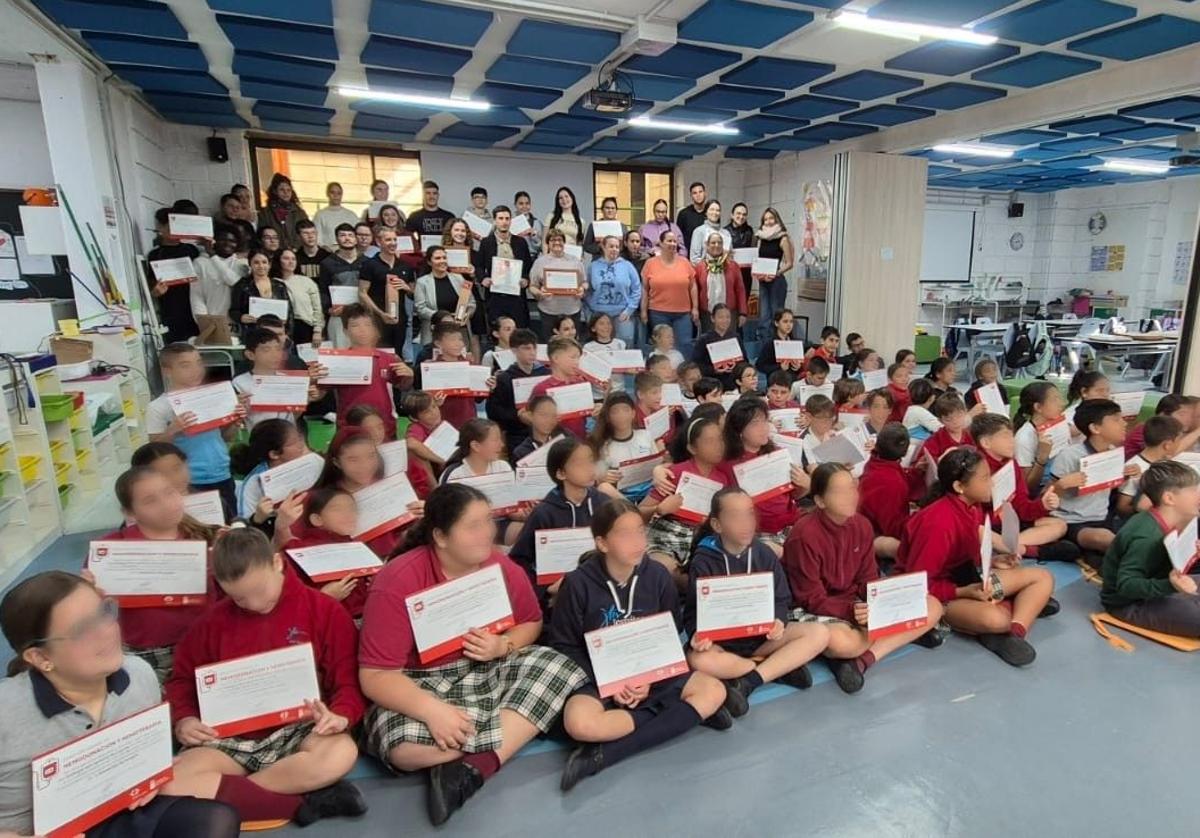 Los niños y niñas distinguidos muestran sus diplomas.