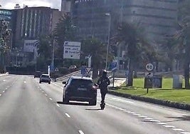 Imagen de la patineta en uno de los carriles de la autovía, detrás de un vehículo.