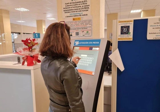 Imagen de una ciudadana solicitando cita previa en las oficinas de del Ayuntamiento de Las Palmas de Gran Canaria, en el edificio Metropole.