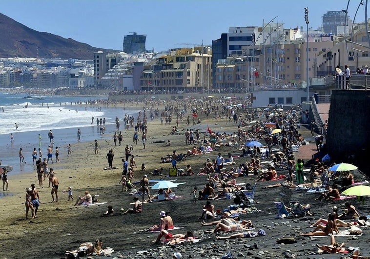 Imagen de la playa de Las Canteras repleta de personas y bañistas.
