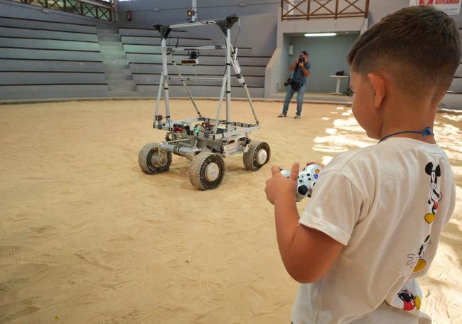 Un niño maneja el rover con el GPS lunar, en el campo de lucha de Lajares.