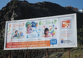 Foto de 2013 de una valla informando del progama canario de acogimiento familiar.